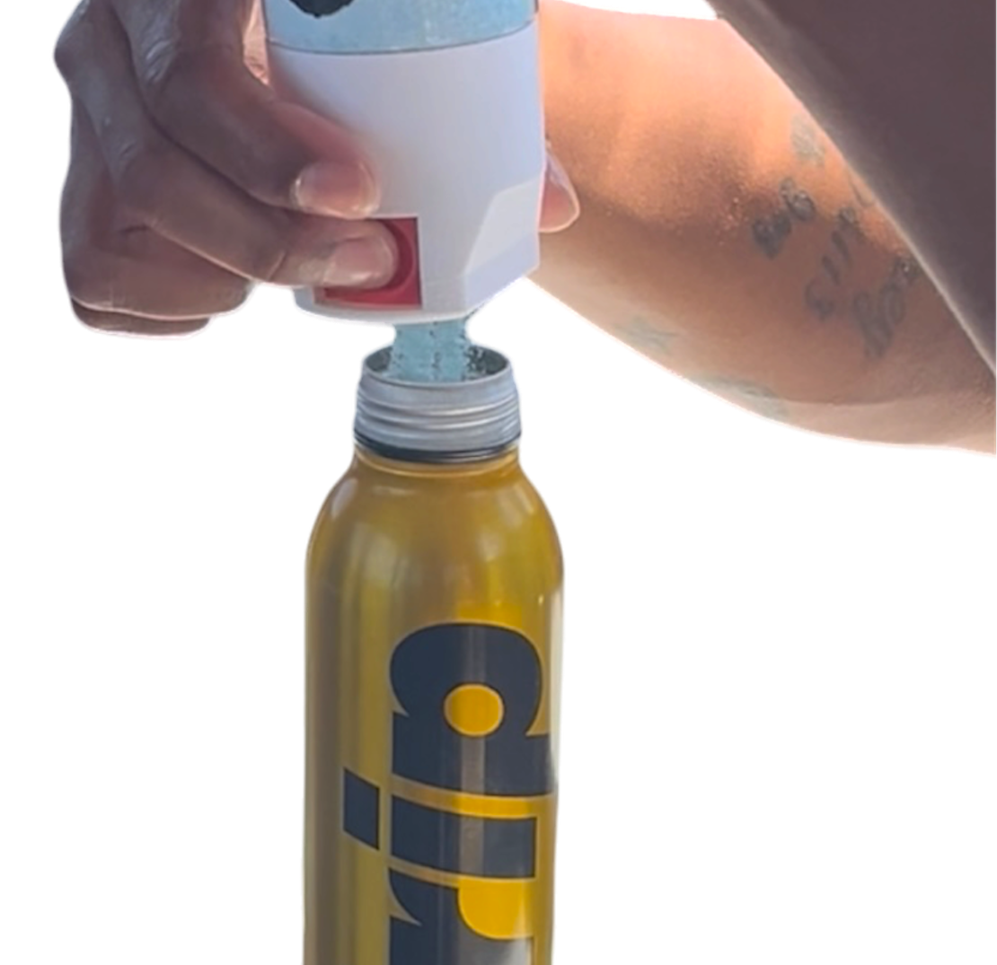 A close-up of a person's hands pressing a white and blue pump dispenser into the neck of a yellow Drip brand can, with the yellow can clearly visible against a plain white background.